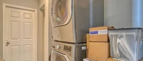 A laundry room with stacked boxes and appliances.