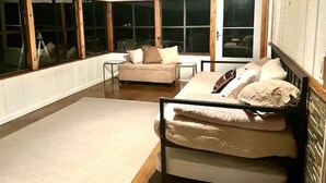 Quarto com cama, sofá e janela.