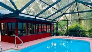 Piscina interior coberta com um edifício vermelho ao lado.