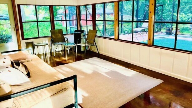 Quarto com cama, janela grande e vista para o exterior.