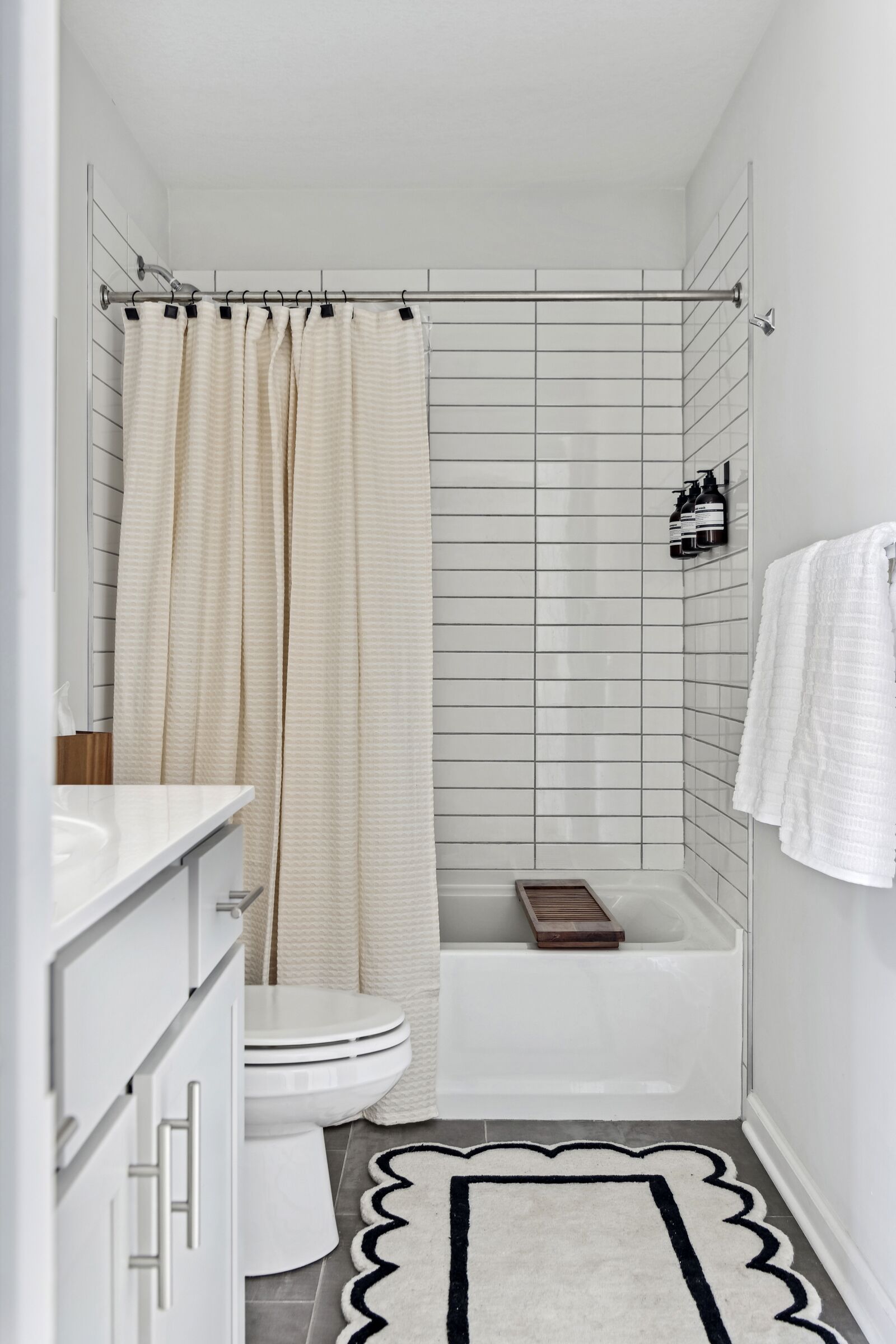 A small, modern bathroom with a toilet, bathtub, and shower curtain.