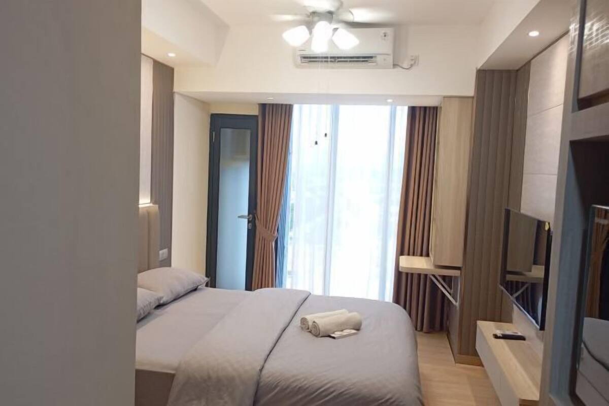 Meja kerja, tirai kedap cahaya, dan seprai linen