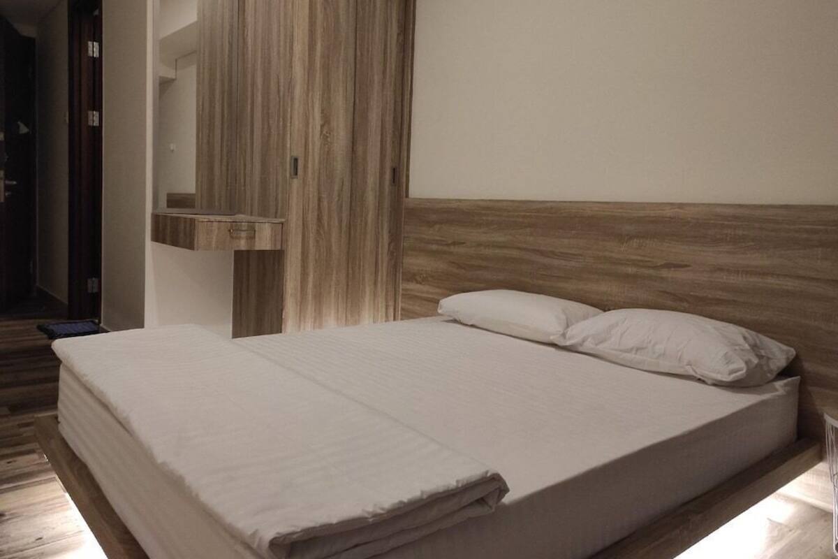 Ein Schlafzimmer mit hölzernem Kopfteil, einem großen Bett mit weißer Bettwäsche und einem Holzschrank.