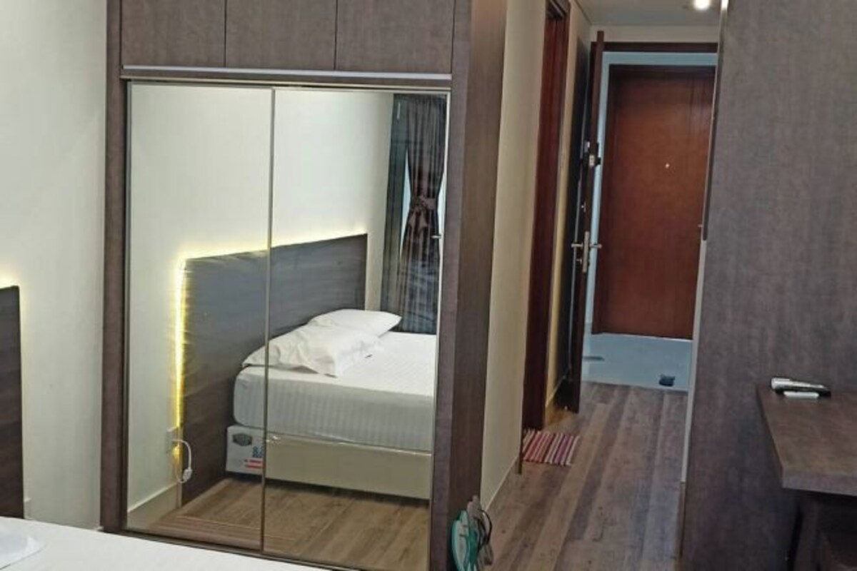 A bedroom with a bed, a wardrobe, and a mirror.