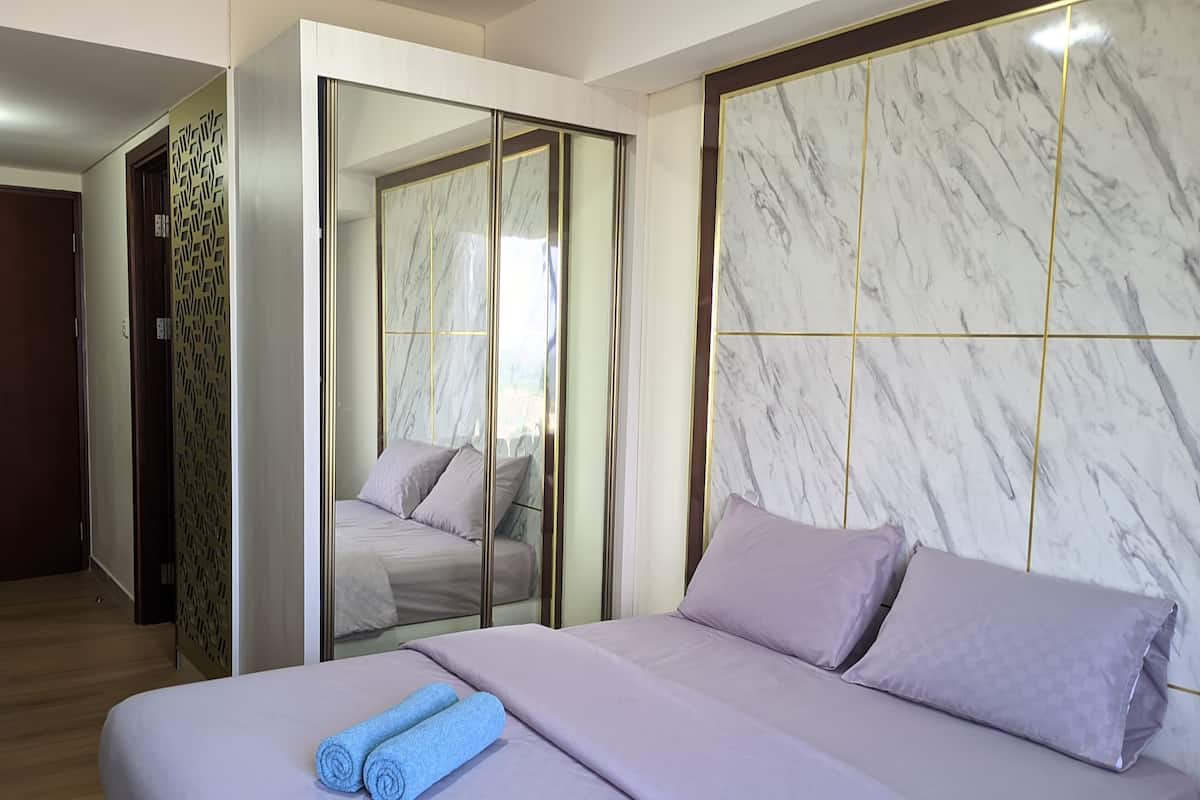 Ein Hotelzimmer mit Bett, Spiegel und Kleiderschrank.