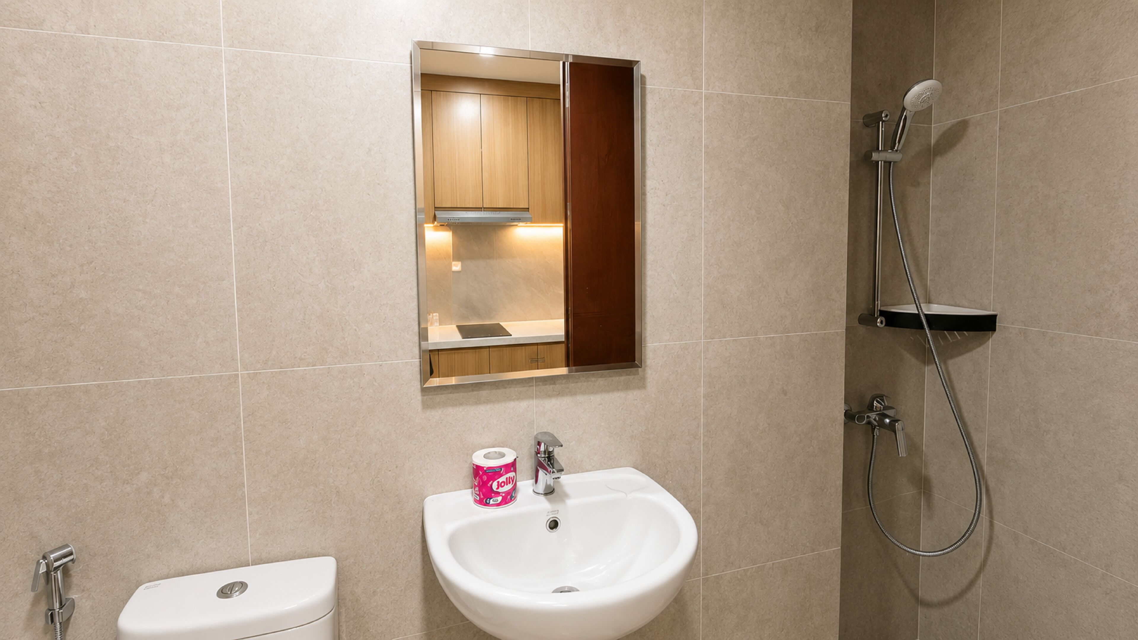 A bathroom with a toilet, sink, mirror, and shower.
