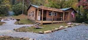A rustic cabin with a porch, a mailbox, and an American flag. - Creekside Cottage –Hot Tub!, Pool Table, Firepit & Pet-Friendly in the Nantahala (Topton)