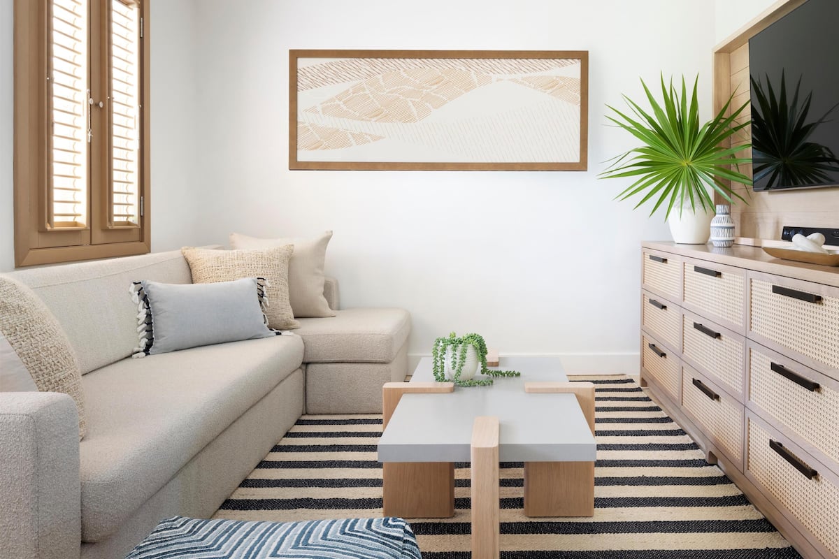 A living room with a sofa, a coffee table, a TV, and a cabinet.