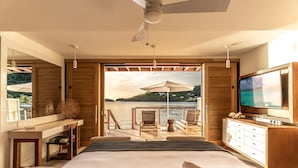 Une chambre moderne avec un grand lit, une télévision, un bureau et une vue sur un lac.