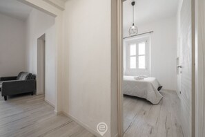 Une chambre à coucher avec un lit, une table de chevet et un luminaire suspendu.