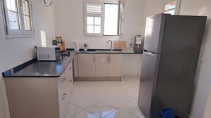 A kitchen with a refrigerator, sink, and cabinets. - Villa LE Rocher (Le Diamant)