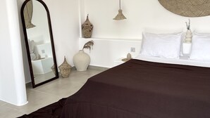 A bedroom with a large bed, a round wall hanging, a mirror, and a hanging light fixture. - Casa Dantes Hotel & Spa (Nungwi)