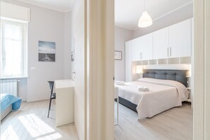 A bedroom with a bed, bedside table, and a window.
