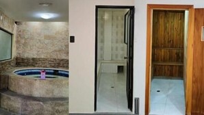 A bathroom with a stone wall, a bathtub, and a wooden door. - JOMALEY REAL HOTEL (Loja)