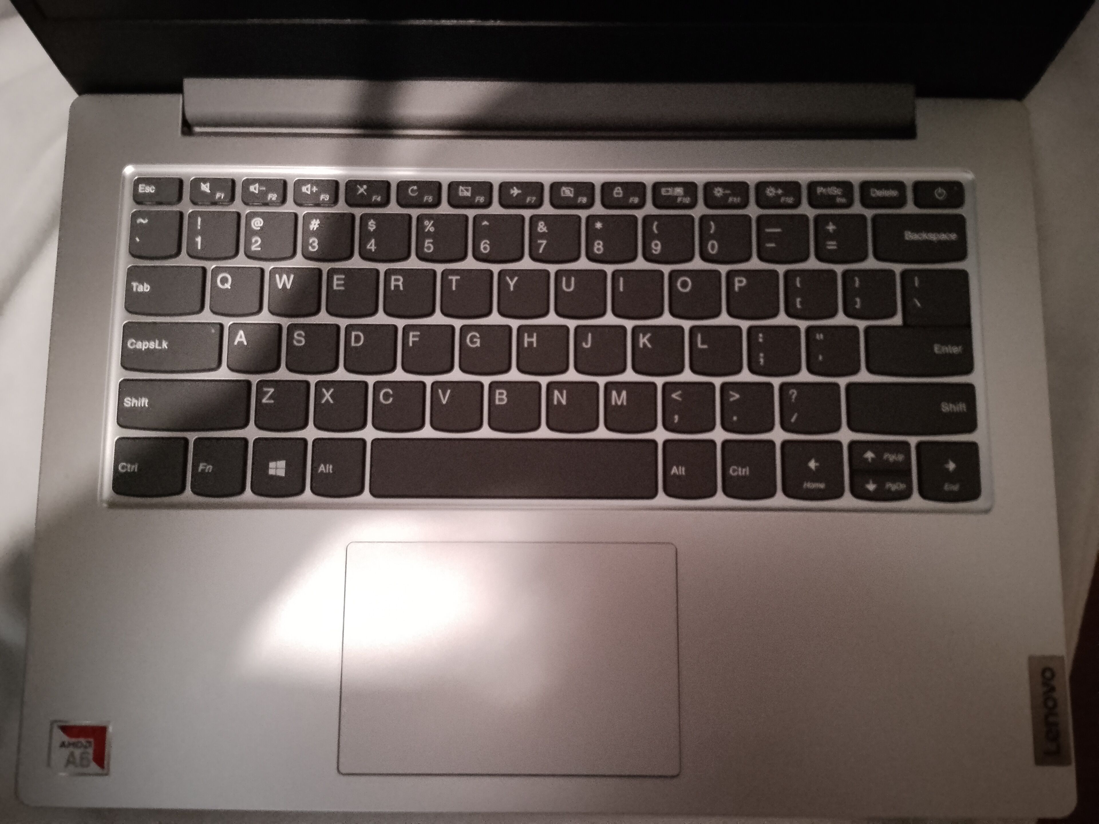 A laptop with a keyboard, a trackpad, and a logo on the bottom right corner.