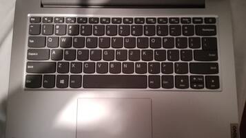 A laptop with a keyboard, a trackpad, and a logo on the bottom right corner.