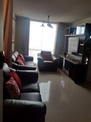 Relax in this stylish living room with a comfortable sofa, flat-screen TV, and coffee machine.