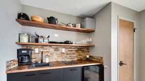 A compact kitchen with wooden shelves, a coffee maker, and a tiled backsplash. - Lakeside One-Bedroom with Balcony/Views! Close to Keystone.  (Dillon)