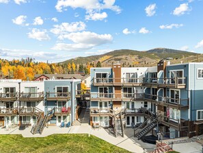 A multi-story hotel with outdoor seating and a view of autumn trees. - Lakeside One-Bedroom with Balcony/Views! Close to Keystone.  (Dillon)