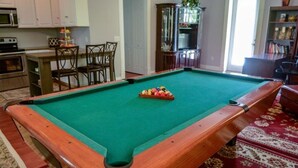 A pool table with a green felt surface, surrounded by a wooden frame. - Wedgefield peaceful retreat (Orlando)