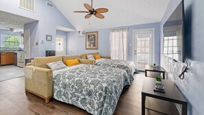 A bedroom with two beds, a ceiling fan, a TV mounted on the wall, and a small table with a plant. - Sweet Home V - Family Cozy House, 20 minutes to downtown, 20 minutes to Airport (Houston)