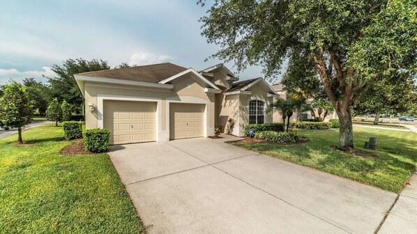 Stunning home with a two-car garage, beautifully manicured lawn, and mature landscaping.
