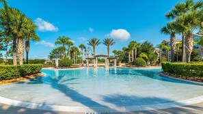 Relax by the serene pool surrounded by lush palm trees and manicured hedges.