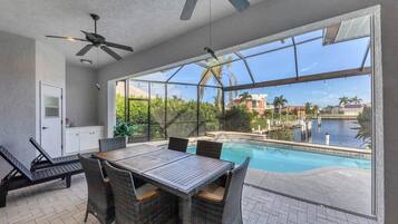 Enjoy a refreshing view of the pool and marina from this spacious balcony, complete with a table and chairs.