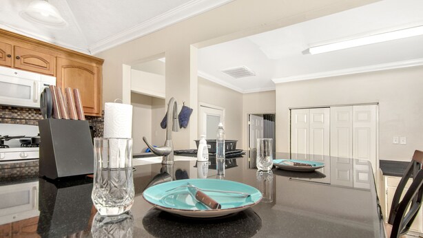 A modern kitchen with a black countertop, stainless steel appliances, and wooden cabinets.