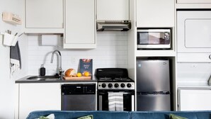 Une cuisine compacte équipée d’une cuisinière, d’un four à micro-ondes et d’un réfrigérateur.