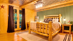 Une pièce en bois avec un lit, une table de chevet et une fenêtre avec des rideaux.