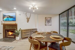 Un comedor con chimenea, una cabeza de venado decorativa en la pared y un amplio ventanal con vistas.