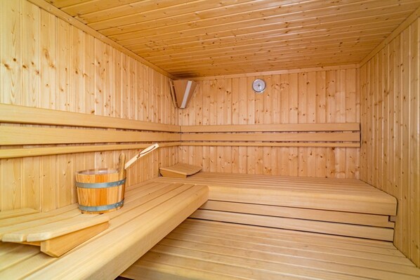 Una sala de sauna con paredes y bancos de madera.