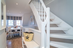 A modern interior with a staircase, a dining area, and a kitchen. - Appartement Dünenglück - Nicolinenhof - Appartement Dünenglück (Wenningstedt-Braderup (Sylt))