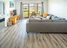 Apartamento panorámico, vistas a la playa | Zona de estar | Smart TV de 60 pulgadas con canales digitales, servicios de streaming