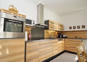 Fridge, microwave, oven, stovetop - Ferienwohnung Cosmo - Direkt am Waldrand mit Balkon und in Strandnähe - Ferienwohnung Cosmo (Glowe)
