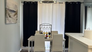 A dining area with a white table, four chairs, a chandelier, and a wine rack with bottles. - The Dolce Cabana located on the golf course in beautiful Diamondhead, MS. (Diamondhead)