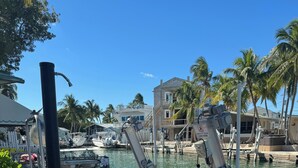 Uma marina com barcos atracados, uma bomba d'água e um contêiner branco no chão.