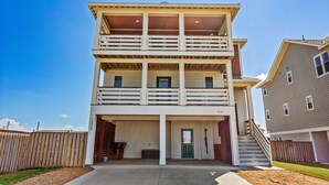 A multi-story residential building with a covered front porch and a garage. - Endless Summer: 1-Min Walk Beach, Pool, Hot Tub (Kitty Hawk)