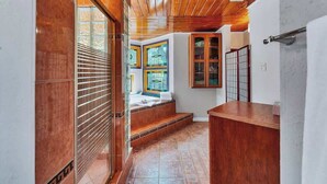 A hallway with wooden flooring, a bench, and a reception desk.