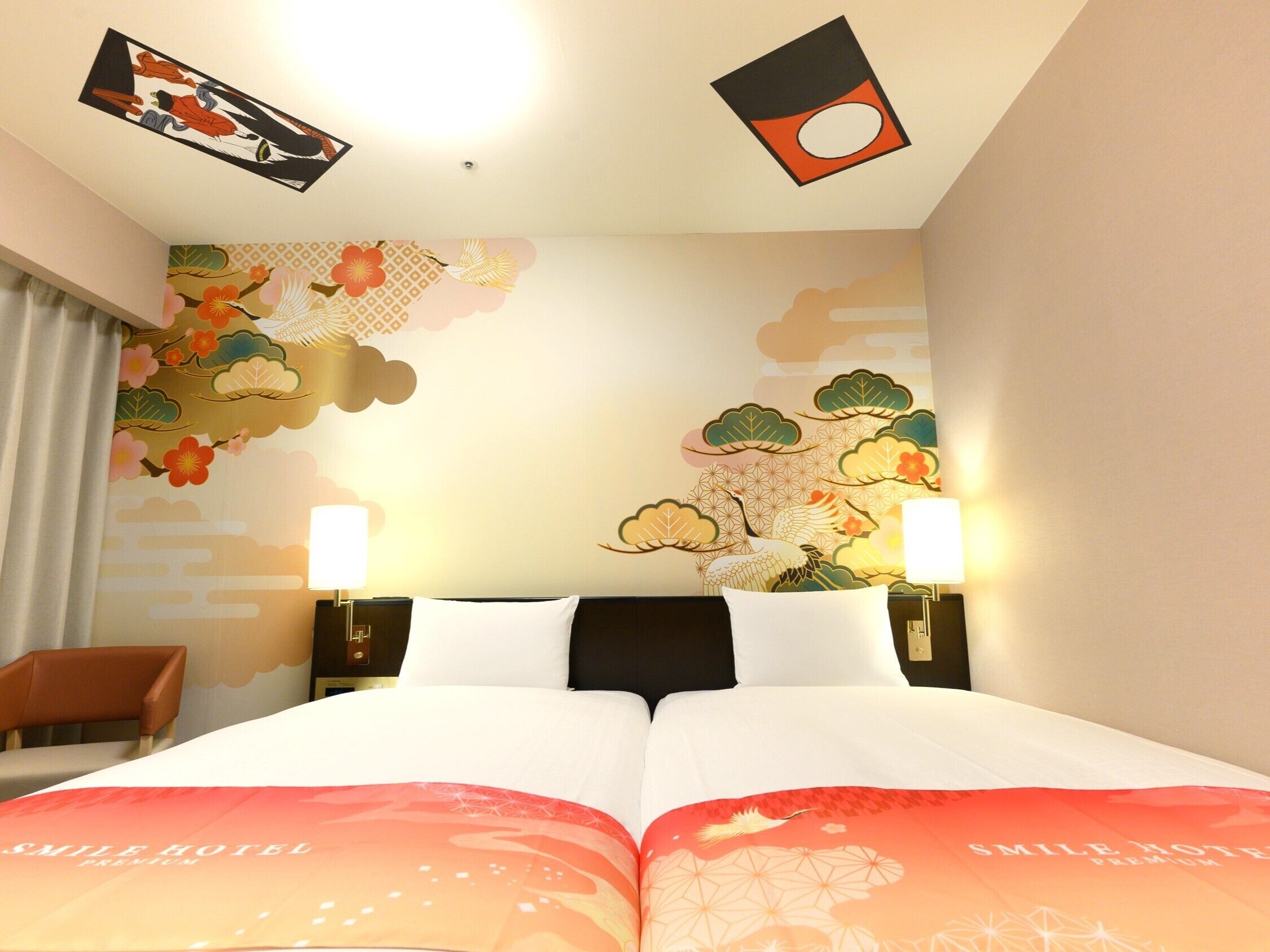 A hotel room with a bed, two bedside lamps, a chair, and decorative wall art.