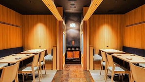 Een congreszaal met houten lambrisering, een middenpad en tafels met stoelen.