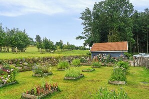 A rural setting with a small house, garden beds, and a fenced area. - Rural charm and beautiful landscape (Svebølle)