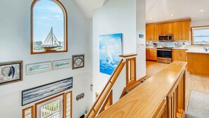 Une cuisine moderne avec des meubles en bois, des appareils en acier inoxydable et une vue sur l’extérieur.