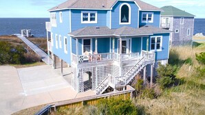 Une maison à deux étages avec un porche et un escalier menant à l’étage supérieur.