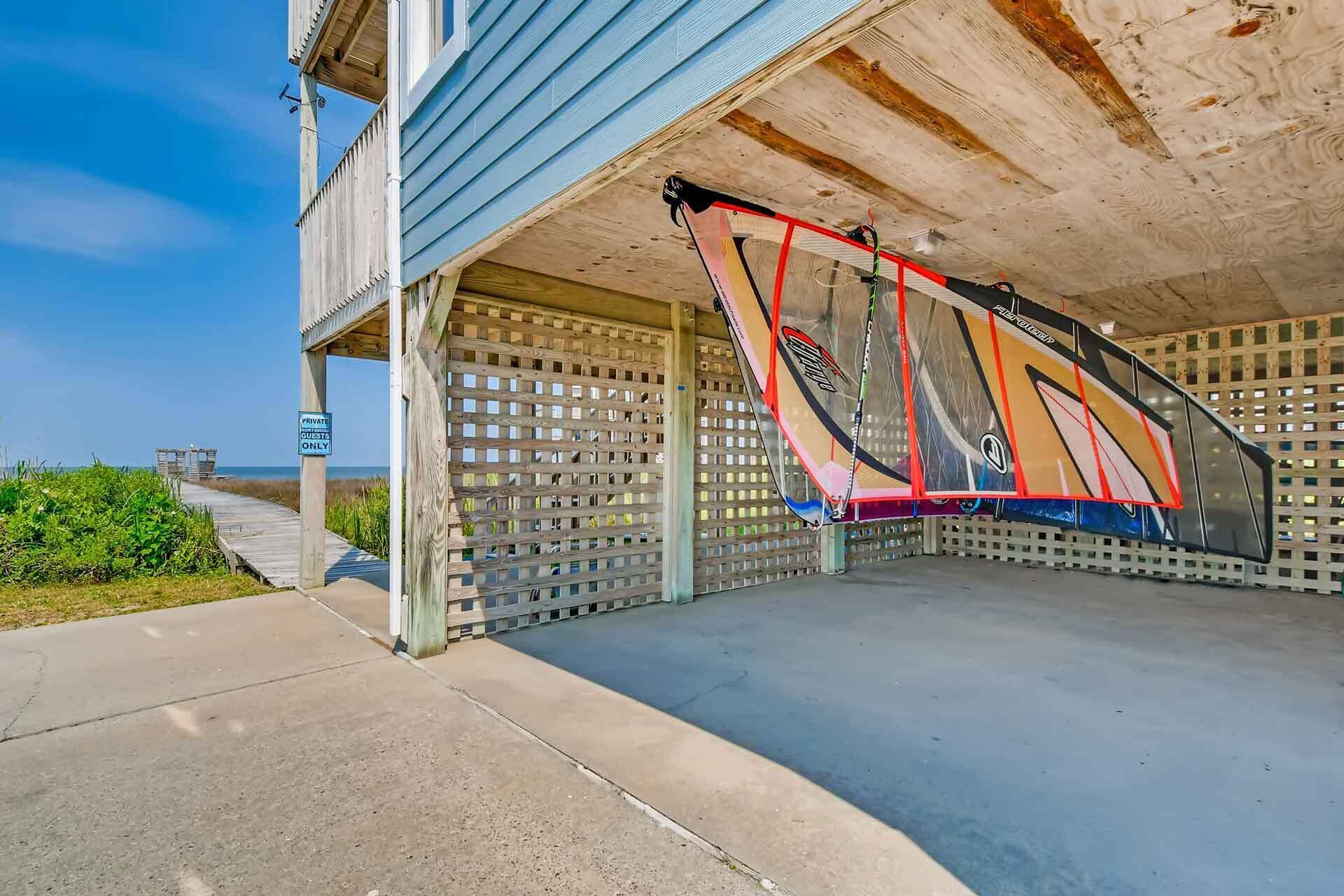 Un espace de stationnement couvert où une planche de surf est appuyée contre le mur.