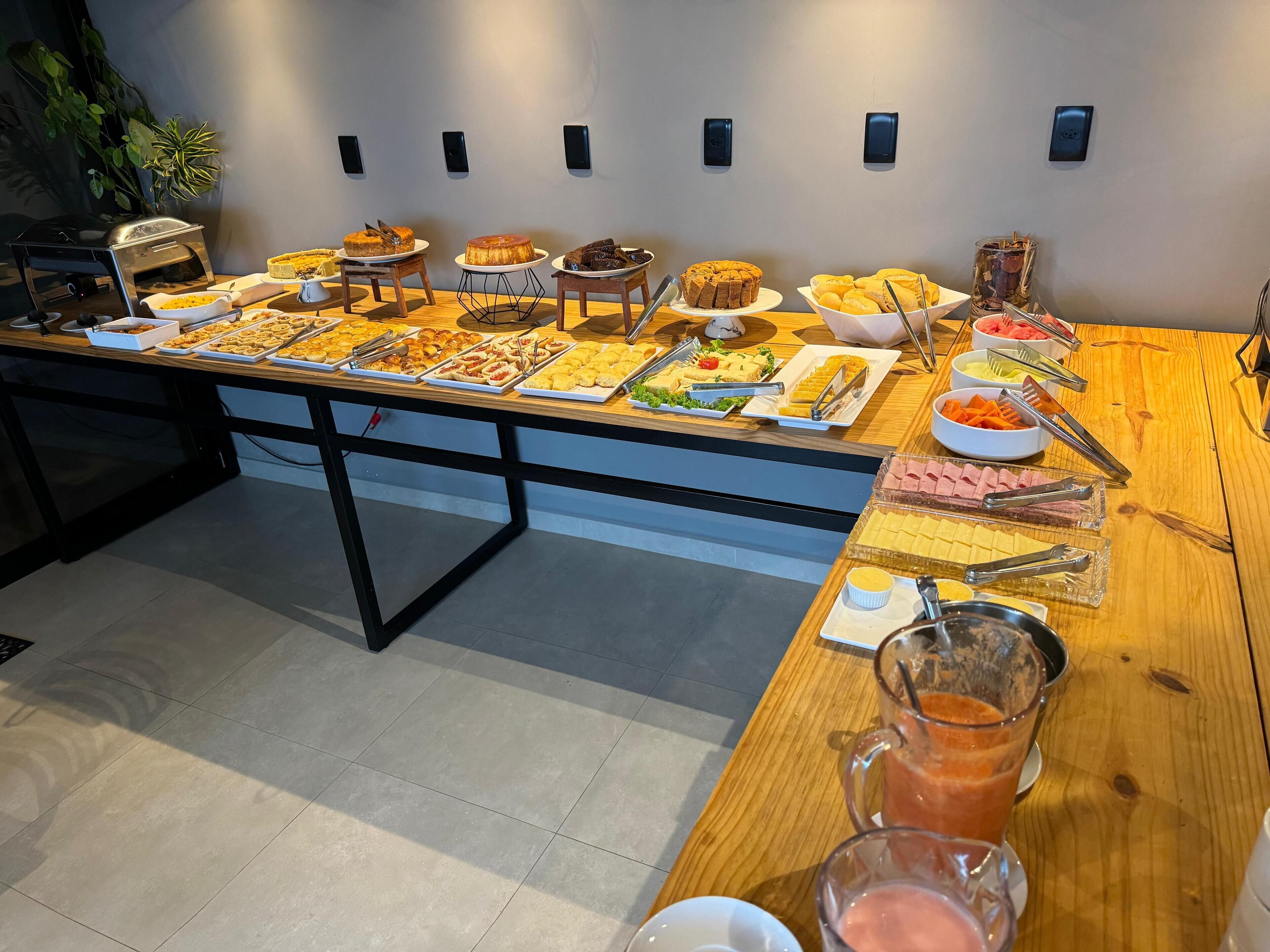 A buffet table with various food items and a pitcher of juice.