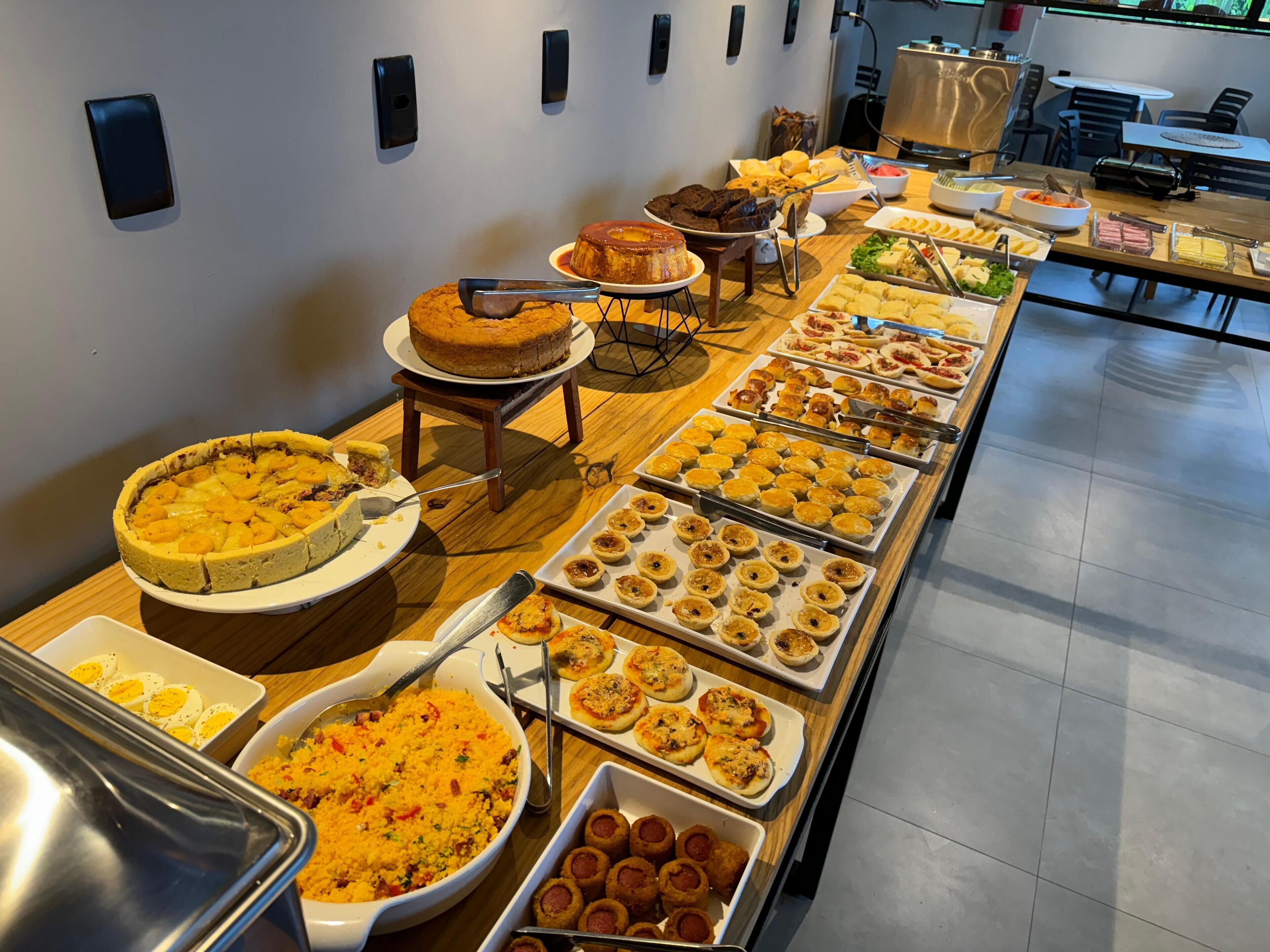Un buffet proposant divers plats, notamment une tarte, des pâtisseries et une salade.