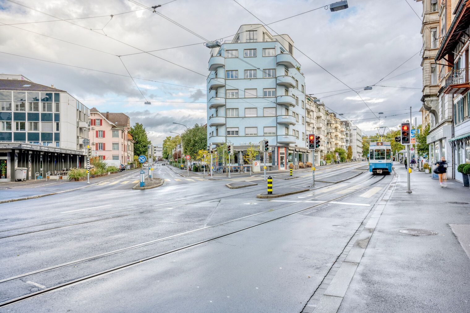 Un tramway à l’arrêt, avec un immeuble à plusieurs étages en arrière-plan.