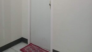 Una puerta blanca cerrada con un pequeño felpudo rojo en la base.